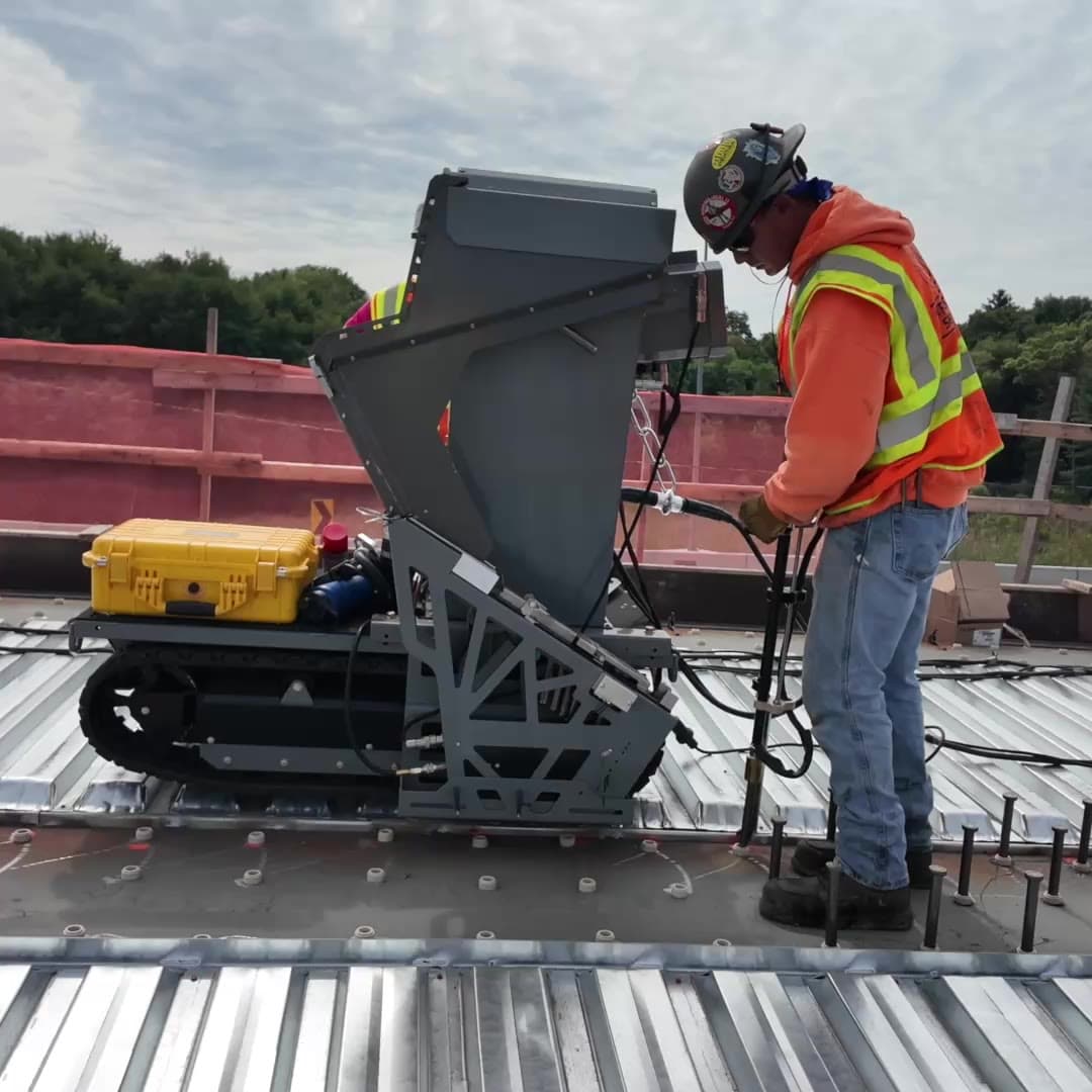 Operator standing beside Stud Caddy as it drives itself along the deck