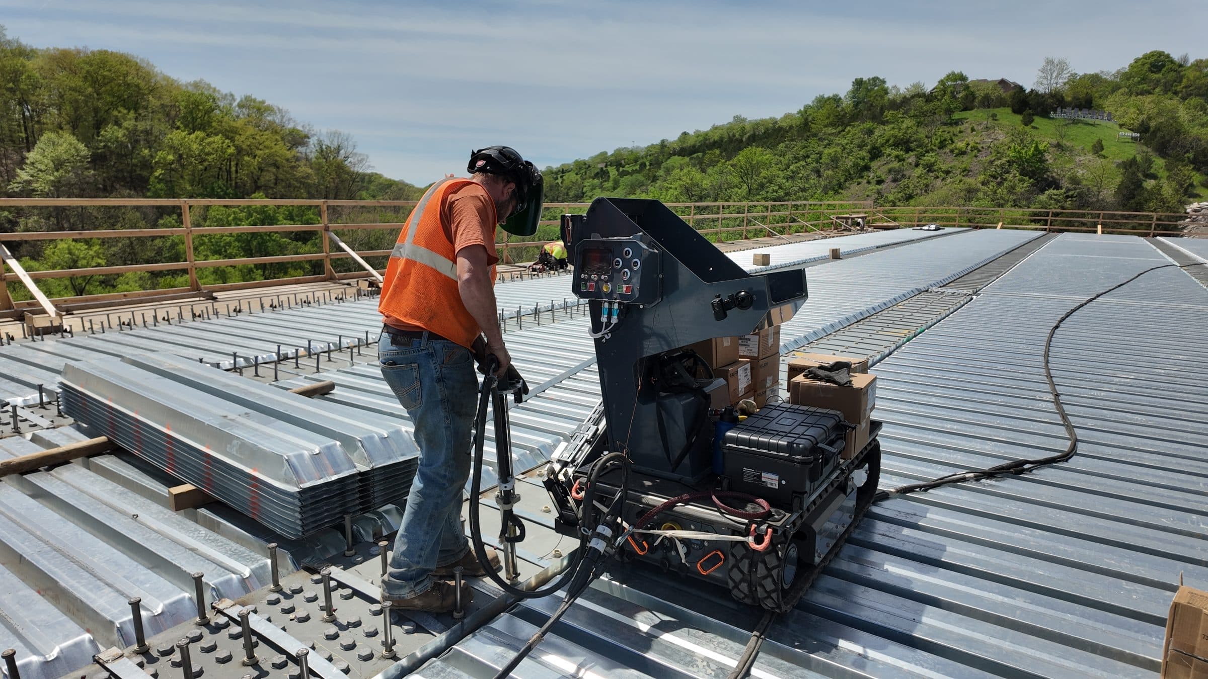 Operator welding studs standing up with Stud Caddy on the I-376 bridge deck