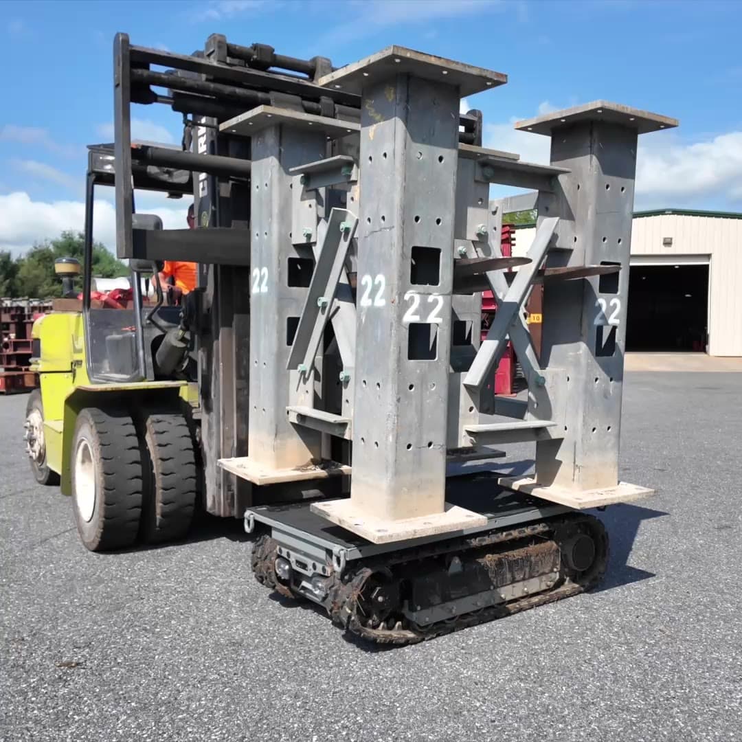 Forklift setting a bundle of steel columns onto the Site Runner deck